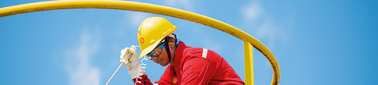 An employee takes measurements from a storage tank at the Bintulu gas-to-liquids plant, Malaysia (photo)