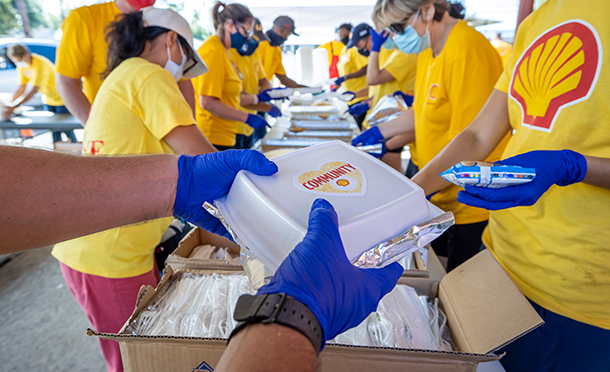 Shell employees participating in community service preparing lunch packages (photo)