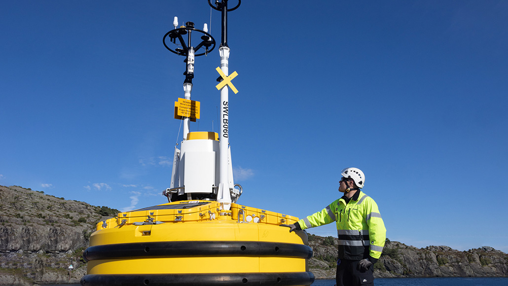 A Fugro representative, checking the assembly of the floating Lidar is completed, Bømlo (Norway) quay side for the Scotwind Metocean survey. (photo)