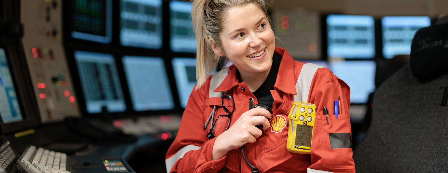 Shell employee in workwear sitting in a control center with radio equipment (photo)
