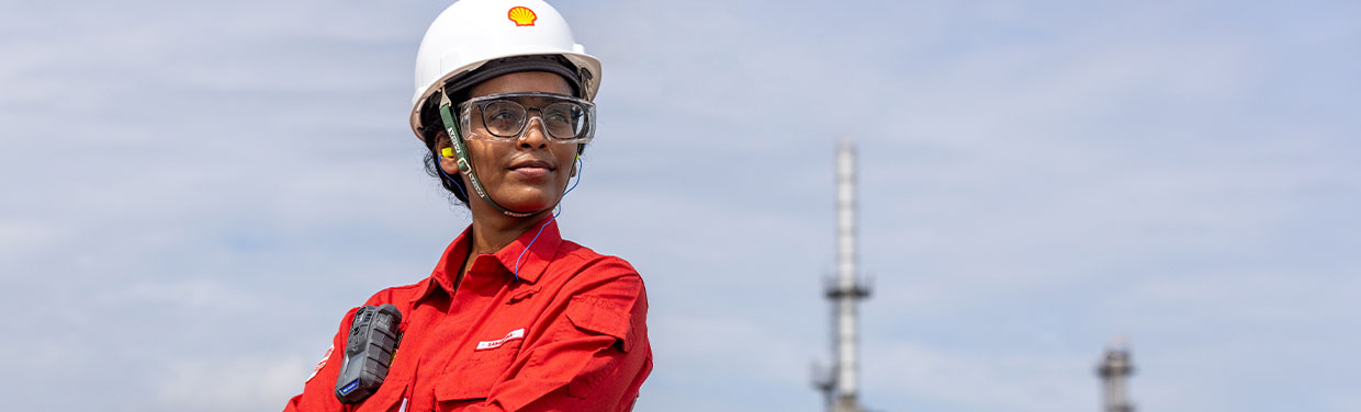 Shell employee in PPE gazing into the distance with blue sky behind (photo)