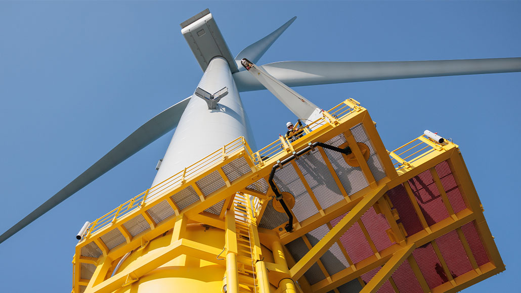Looking-up perspective of a wind turbine against blue sky (photo)