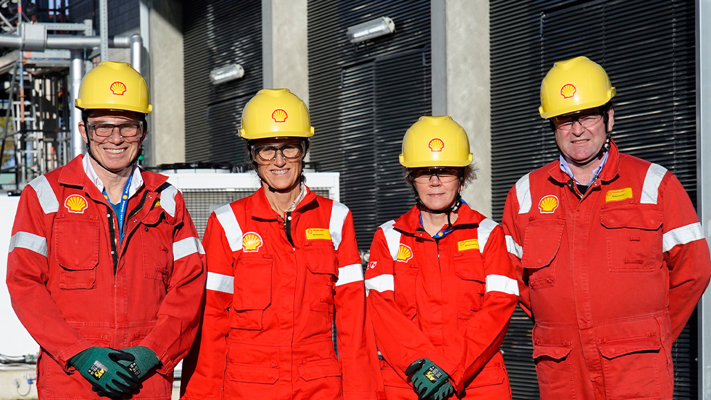 Four members of the Sustainability Committee in PPE visiting the Shell Park in Rheinland, Germany, smiling into the camera (photo)