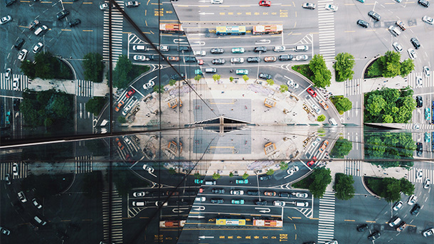 aerial view of traffic reflected in a skyscaper building