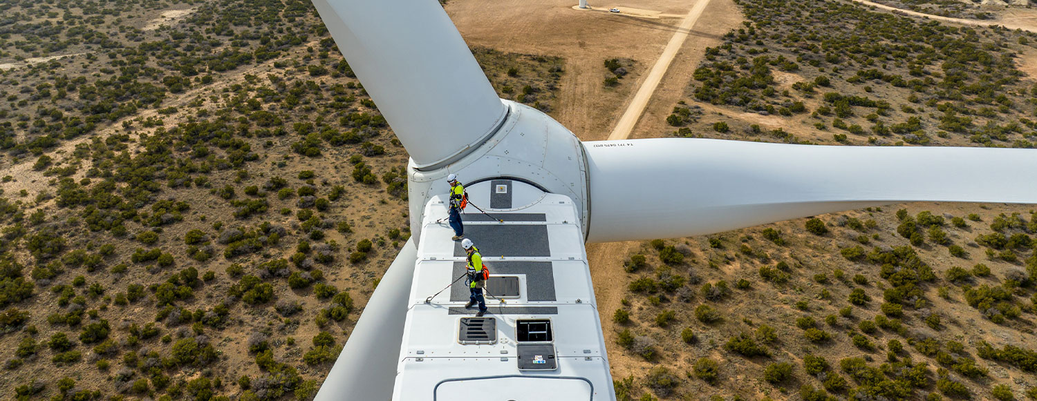 Two contractors completing maintenance work on top of the wind turbine’s nacelle at Brazos Wind Farm (photo)