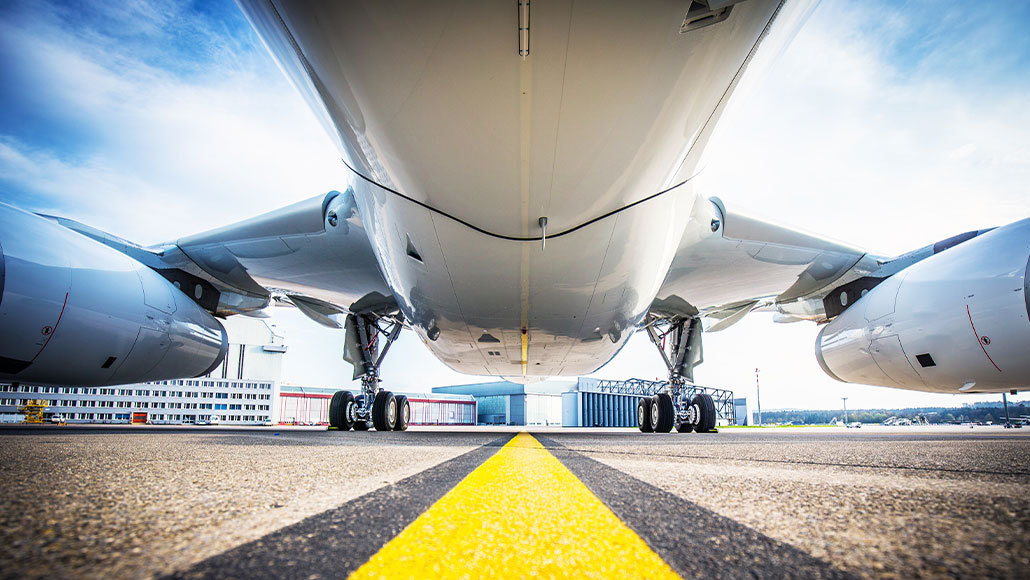 Underside of aircraft fuselage, seen on the tarmac at an airport (photo)