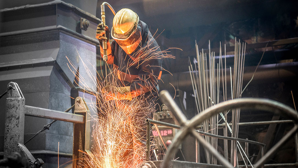 Man in protective clothing at work in steel foundry (photo)