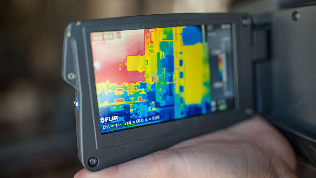 An employee at a well pad inspects with her infra-red camera detecting any potential dangerous gases or leaks (photo)