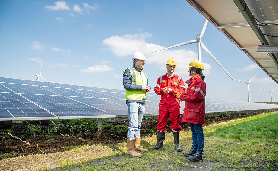 Three Shell employees stood next to solar panels at Pottendijk Energy Park. (photo)