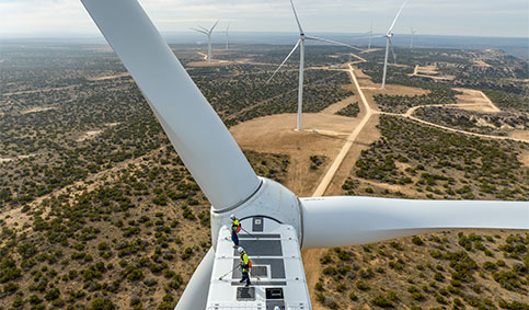 Two contractors completing maintenance work on top of the wind turbine’s nacelle at Brazos Wind Farm (photo)