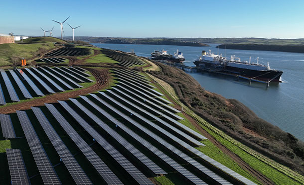 overview of an LNG ship docked in Wales next to a field of solar panels