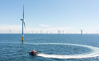 Offshore wind park with small motorboat in the foreground