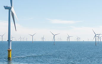 Offshore wind park with small motorboat in the foreground