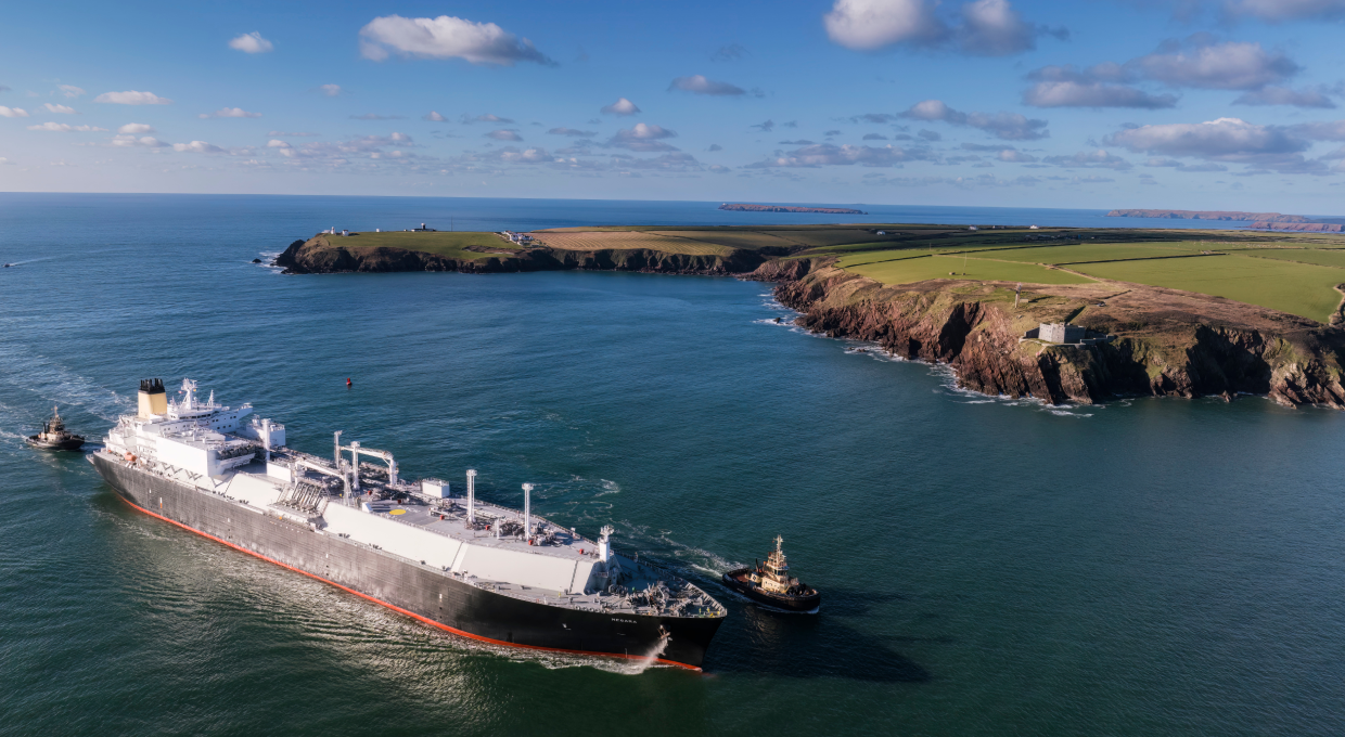 A Shell LNG vessel moving through water with land behind (photo)