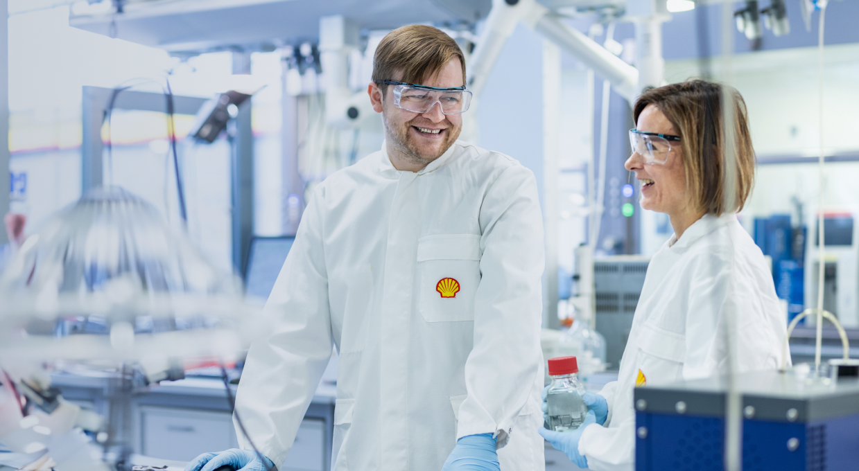 Portrait of two smiling scientists wearing protection glasses in laboratory (photo)