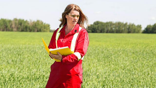 An employee stands in a field near a Quest C02 injection well northeast of Edmonton, Canada (photo)