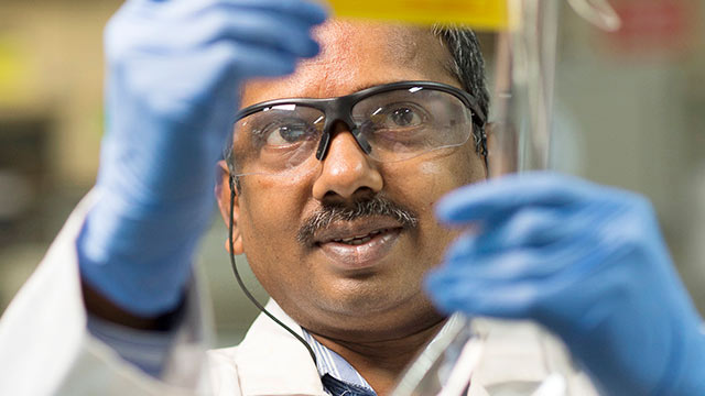 Laboratory worker checking a sample in laboratory at Taloja lubricants-oil plant, Taloja, India (photo)