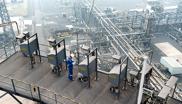 An employee during a routine inspection at the Hazira LNG regasification plant in India (photo)