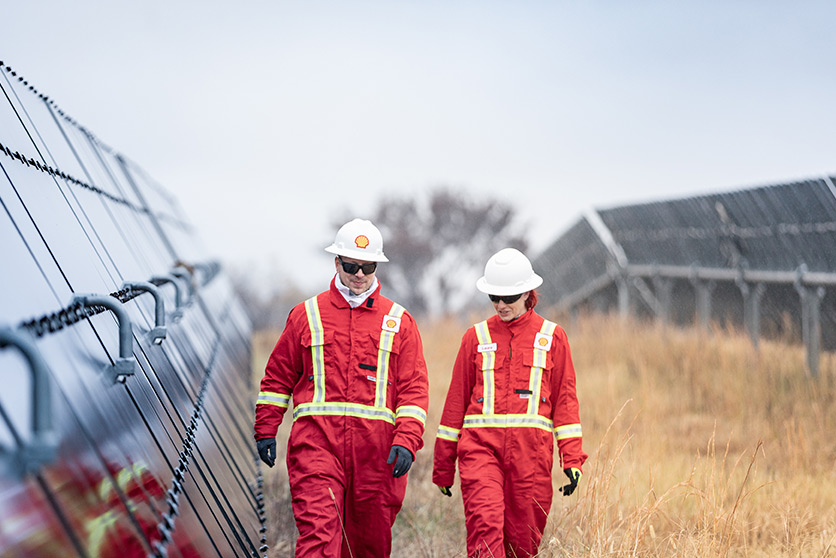 Two workers walk alongside solar panels and equipment at the Silicon Ranch Solar Farm, Tennessee, USA (photo)