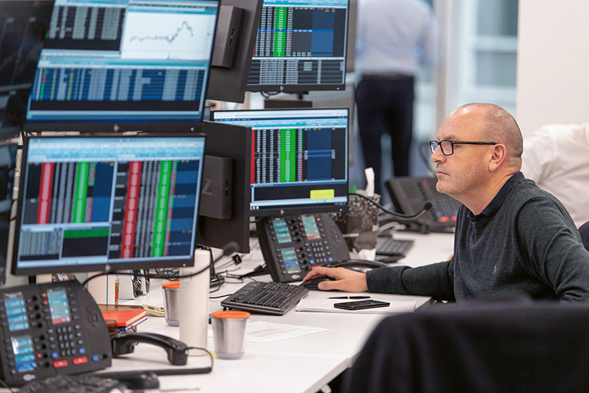 An employee using trading computer and screens for the marketing and trading crude oil (photo)
