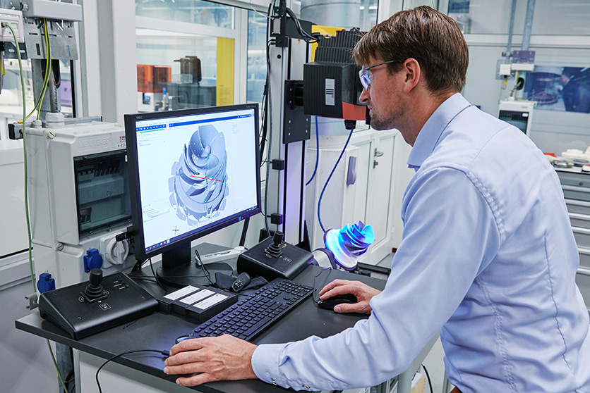 An employee operating a 3D printing geometrics scanner in the Shell Technology Centre in Amsterdam (photo)
