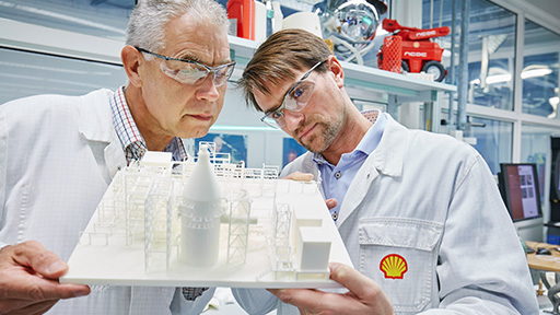 Two Shell employees inspecting a 3D printed site model. (photo)