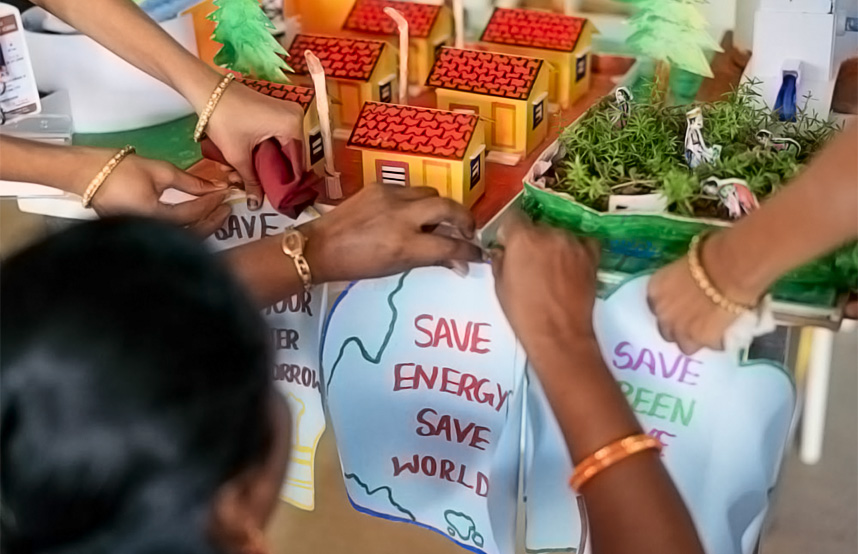 Woman with a model of houses and a banner saying: Save energy , save world (photo)