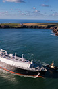 Aerial view of an LNG vessel passing by cliffs and green fields. (photo)