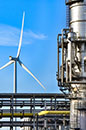 Wind turbine viewed through pipework of Shell Chemicals park (photo)