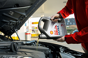Worker refilling a car with Shell Helix Ultra (photo)