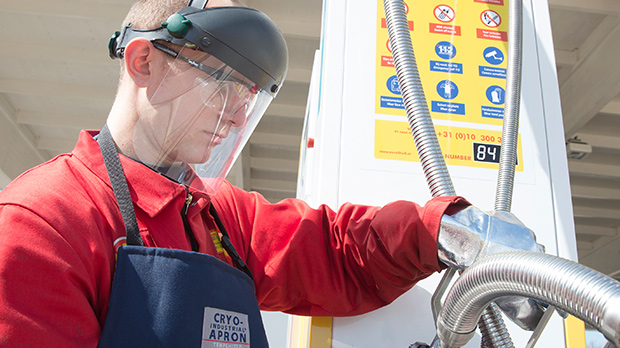Employee in protective clothing refueling with LNG at Shell LNG station in Rotterdam (photo)