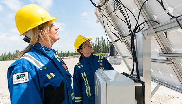Workers looking at methane detection technology – pilot as part of Methane Detectors Challenge at an unconventional gas wellsite near Rocky Mountain House, Alberta, Canada, 2017 (photo)
