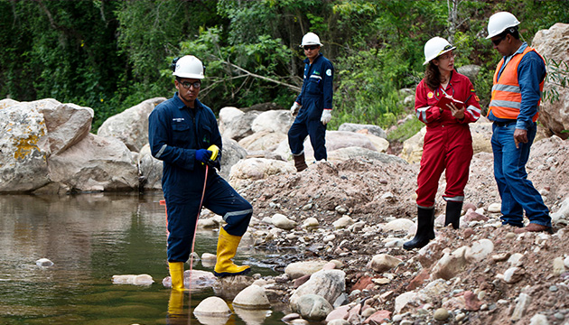 Female environmental adviser to Shell Bolivia, takes measurements from a nearby river with the help of three community coordinators at the Jaguar Camp in Bolivia. (photo)