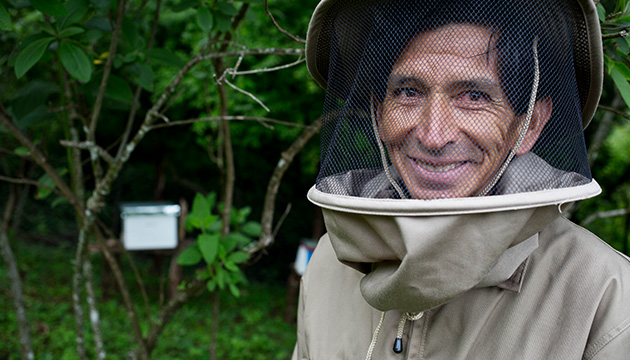 Man poses for a photo in his beekeeping suit at the Jaguar Camp in Tarija, Bolivia. (photo)