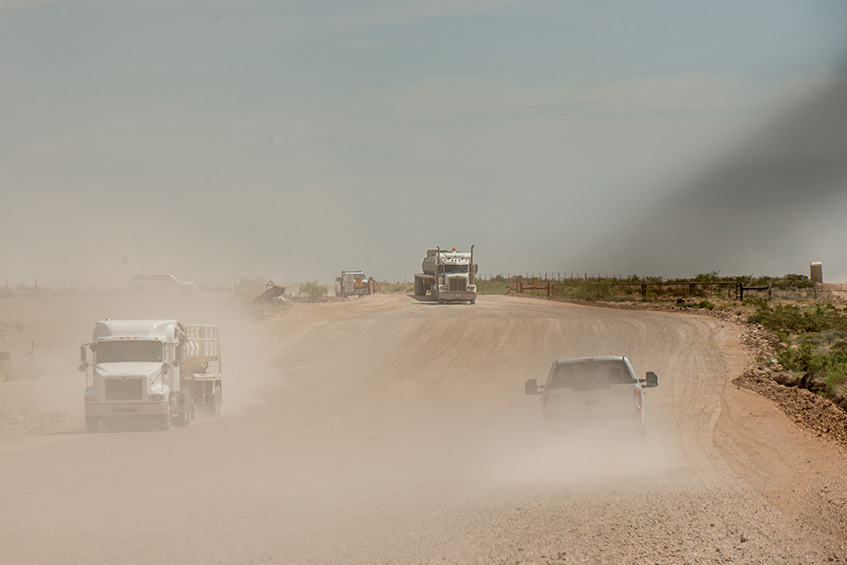 Trucks on a two-way road near the Permian Basin, USA. (photo)
