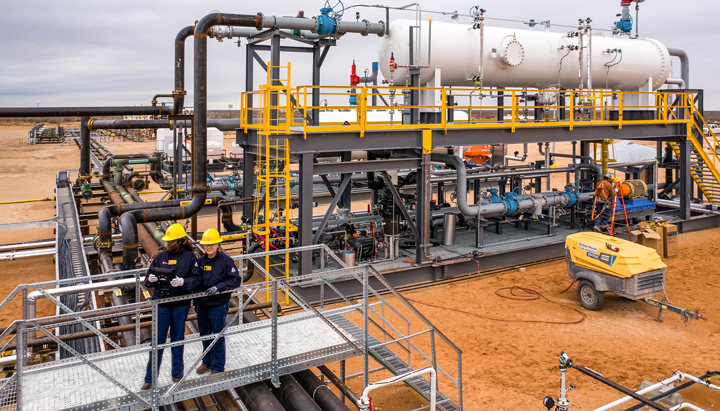 Two Shell employees in front of the low pressure separator, the field of the future, a wellpad in the iShale® Program, Permian Basin (photo)