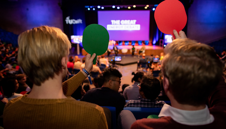 Two participants using their voting bats, in an audience at The Great Energy Debate 2019 (photo)