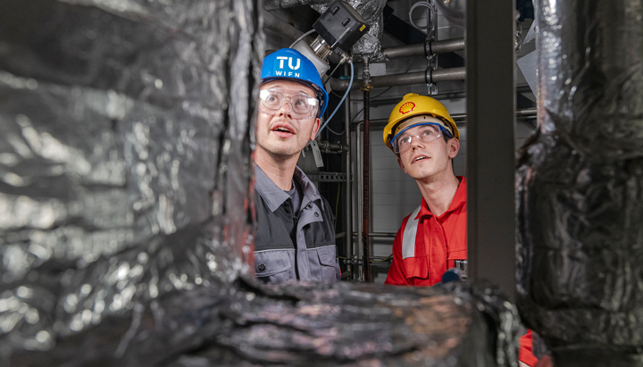 Two men next to the CO2 adsorber inside the pilot plant process container at the Vienna Green CO2 Pilot Plant (photo)
