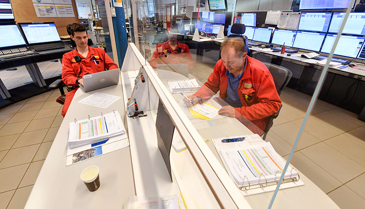 Two men with a plastic screen between them. working in a control room at Moerdijk, in the Netherlands. (photo)