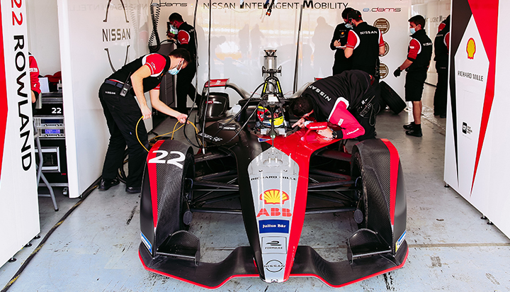 A team of people working on a Formula-E race car. (photo)