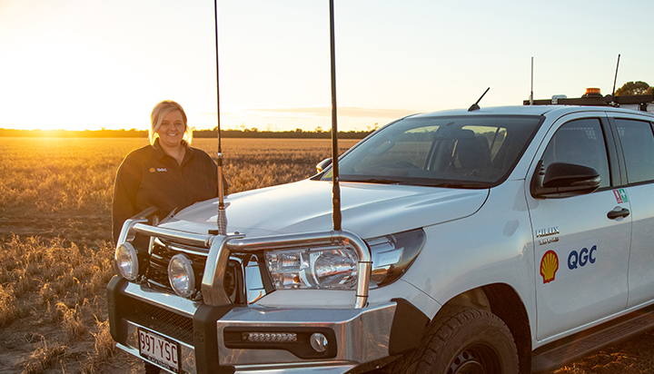 Australian Shell QGC employee standing beside her vehicle in the fields. (photo)