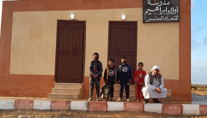 A man and four boys standing outside a building in the Western Desert, Egypt. (photo)
