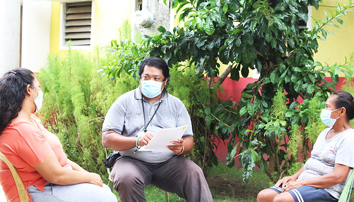 A Shell community coordinator and two women, all wearing masks, meeting outside near their homes in the Philippines. (photo)