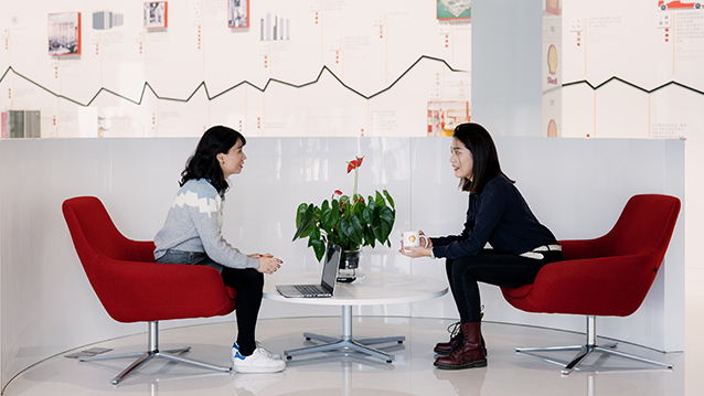 Two women talking at an office in Beijing, China. (photo)