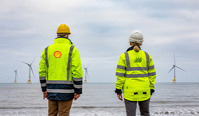 Two workers on the beach looking towards the Scotwind offshore park location (photo)