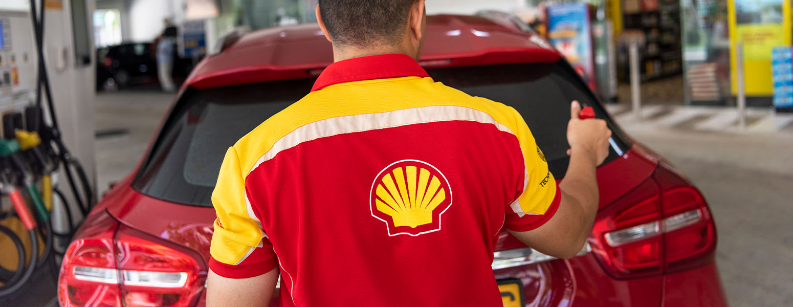 Service champion employee washing a car rear window at a Shell retail site in Singapore, Asia (photo)