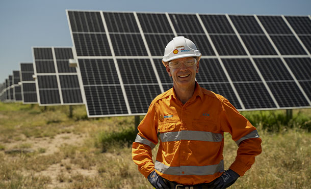 Shell employee standing infront of Solar panels farm, Australia (photo)