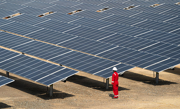 Shell employee stands next to large solar farm, Qatar (photo)