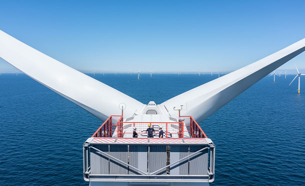 Close up aerial image showing people at the top of an offshore wind turbine (photo)