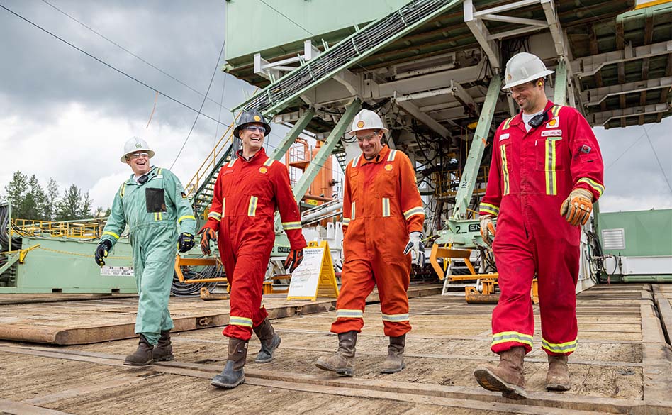 four Shell employess wearing PPE walking together (photo)